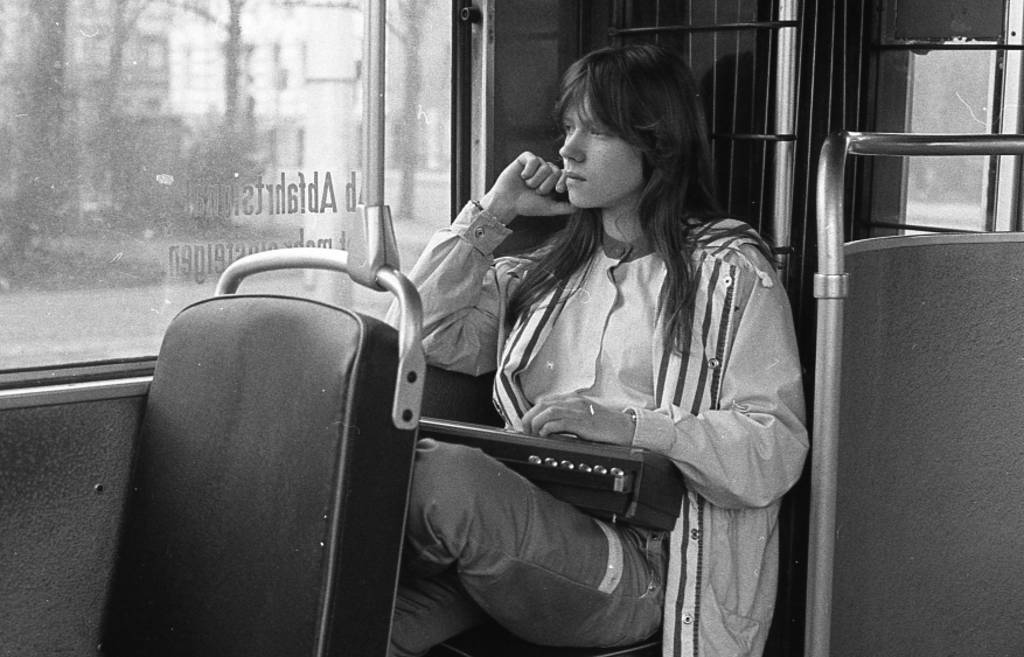 Junges Mädchen mit einem Kofferradio in einer Straßenbahn in Dresden, 1986.